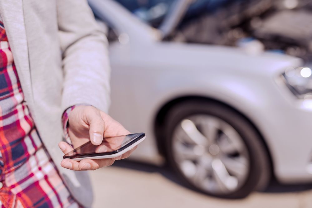 Openbay Man Holding Phone in Front of Car